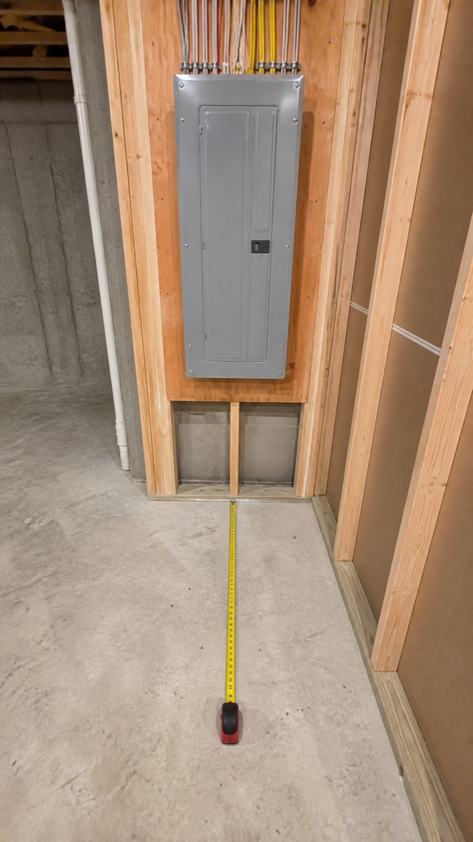 Synthetic wide view of an electrical panel with a tape measure showing clearance